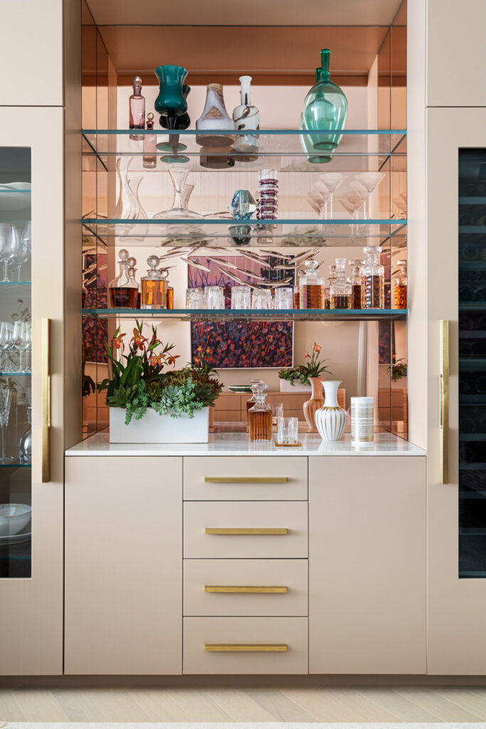Design details like custom millwork and glass shelving for an at-home bar, designed by Andrew Suvalsky.