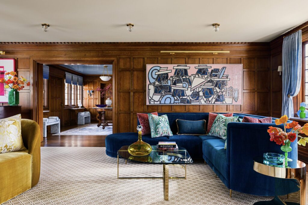 Custom wood-paneled walls and shapely furniture are elegant design details in this Bronxville living room designed by Andrew Suvalsky. 